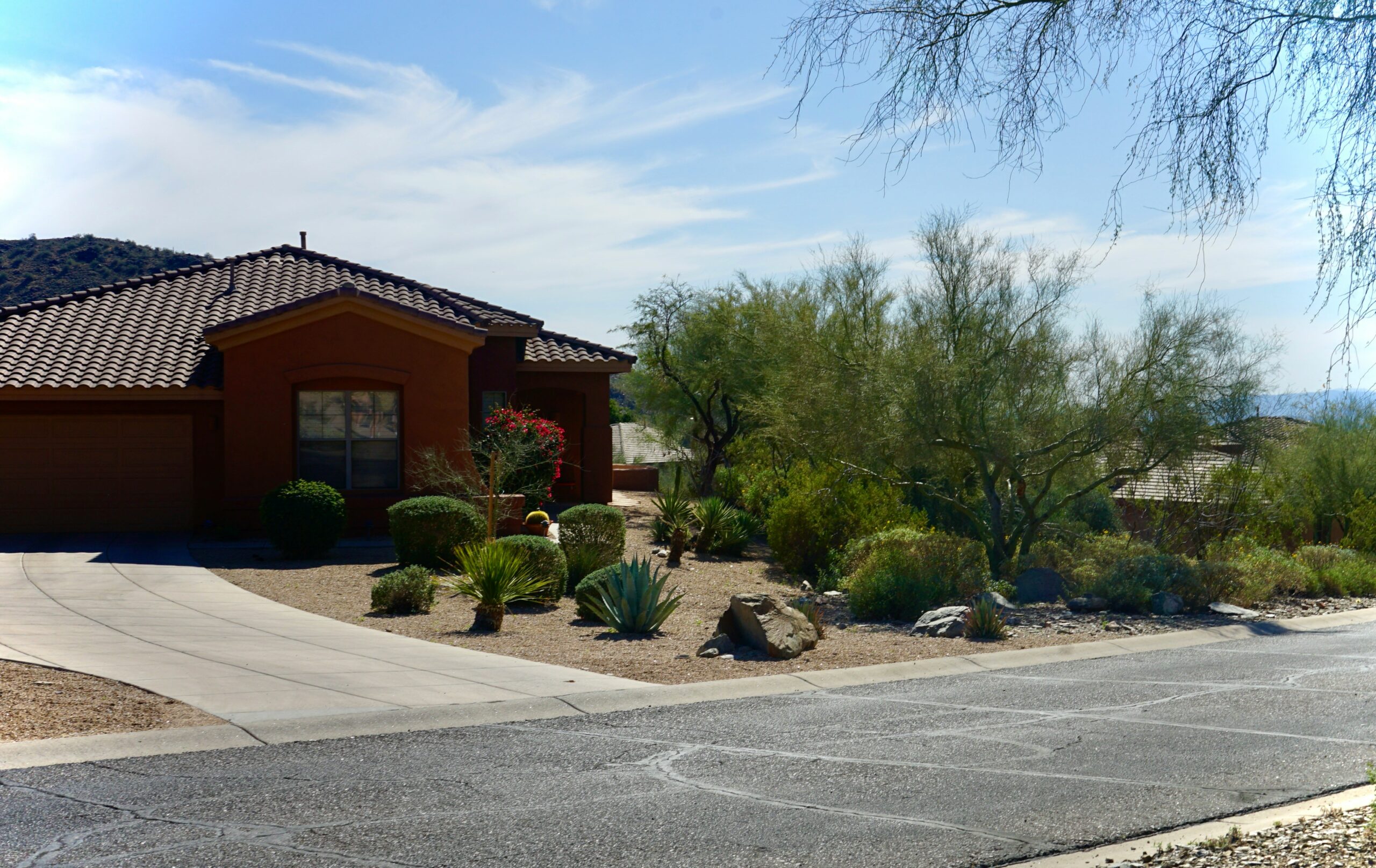 Southwestern Arizona home with garage, driveway and desert landscaping