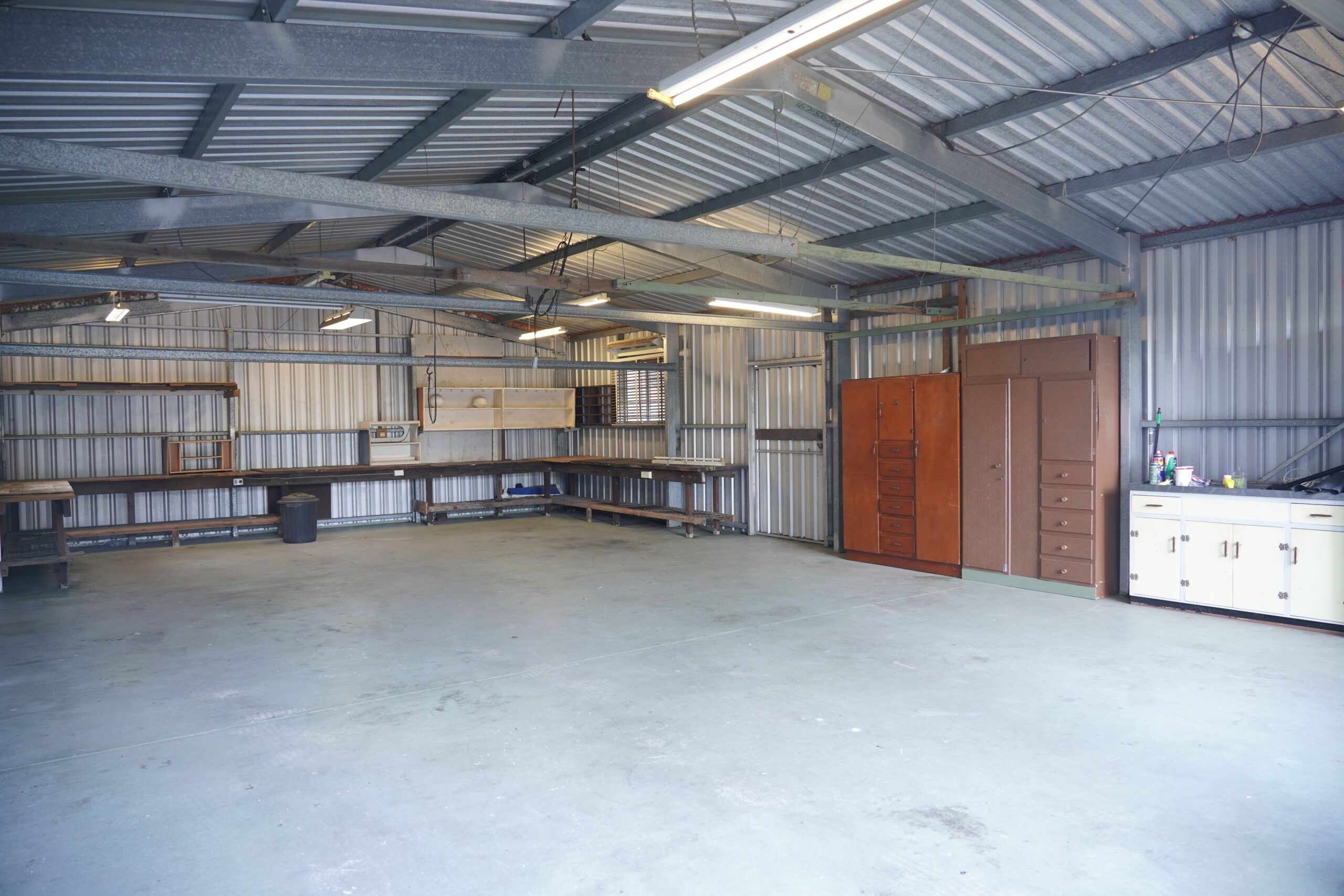 Large steel workshop interior with open floor space, storage and work areas
